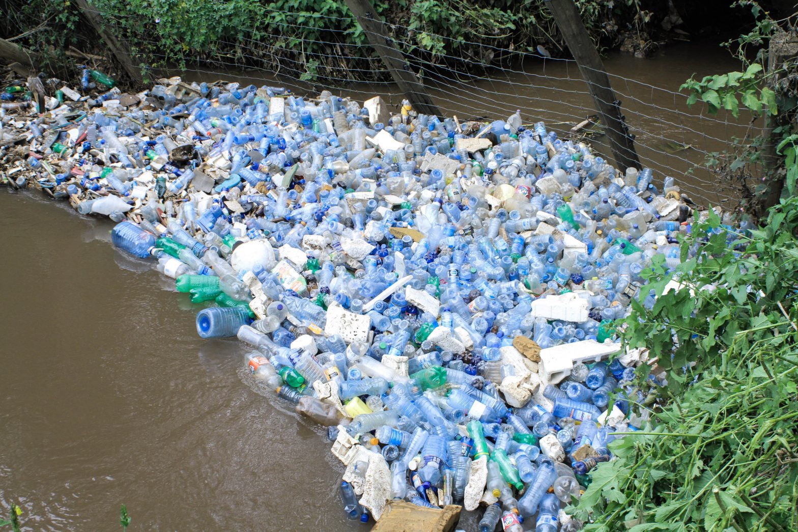 Plastic bottle waste stuck at a wire filter on Njoro River, Kenya © James Wakibia